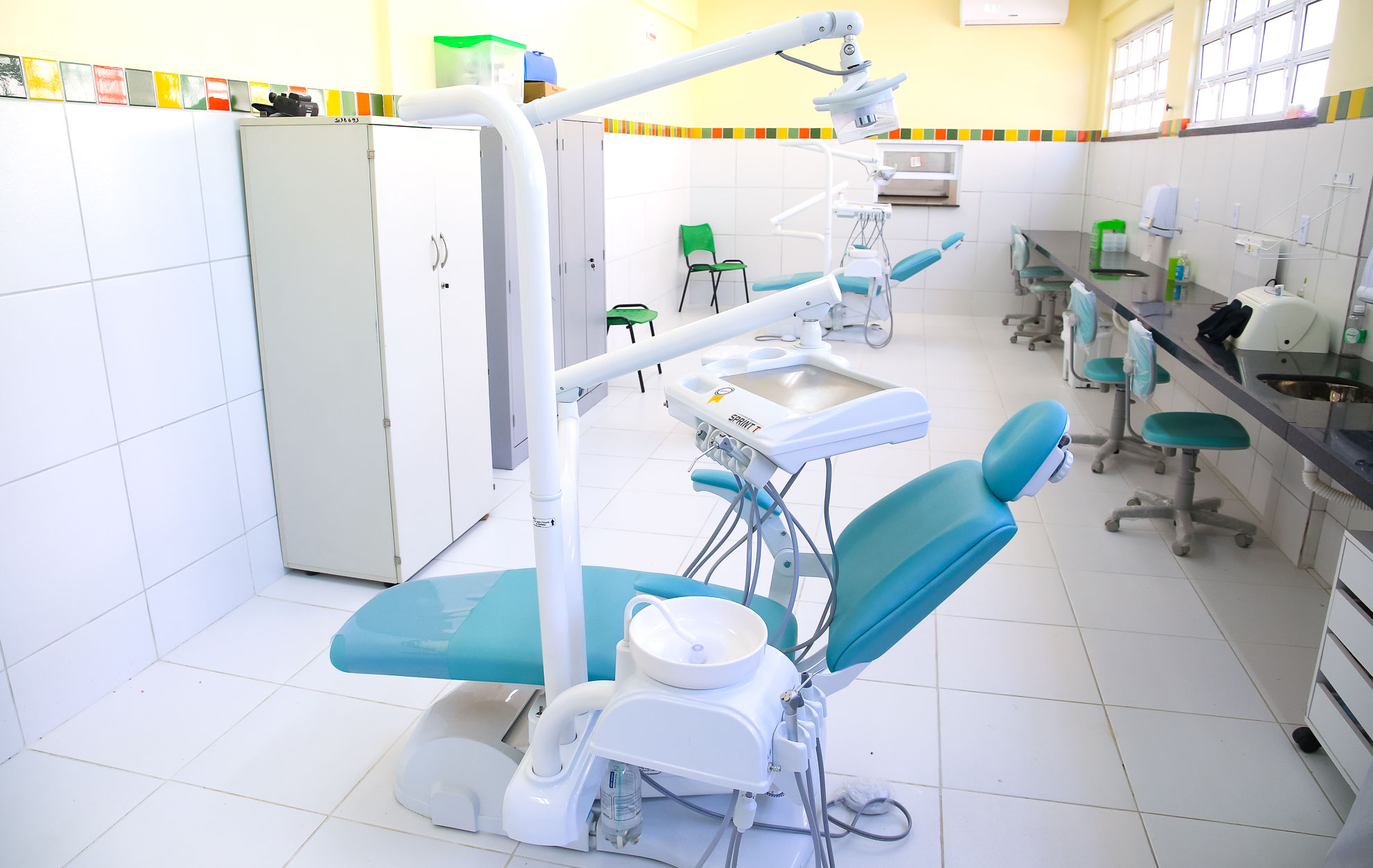 sala de odontologia com duas cadeiras de dentistas e equipamentos